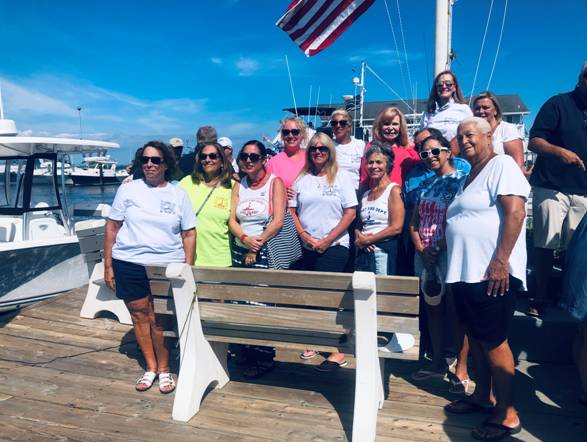 A group of people posing for a photo on a boat

Description automatically generated