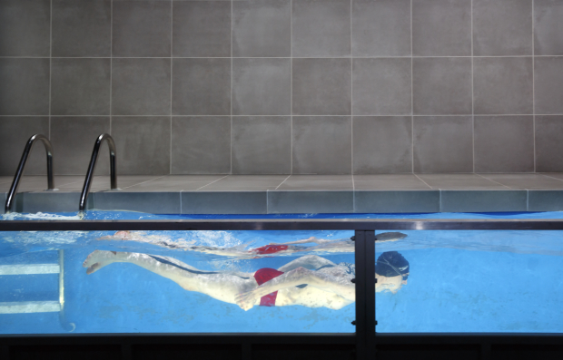 Ray (Alex Breaux) swims a lap in the pool that scenic designer Riccardo Hernandez created for Red Speedo.