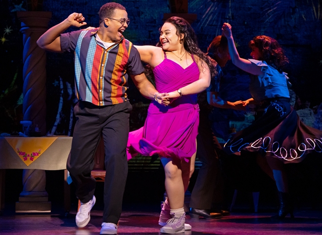 A person and person dancing on a stage
Description automatically generated