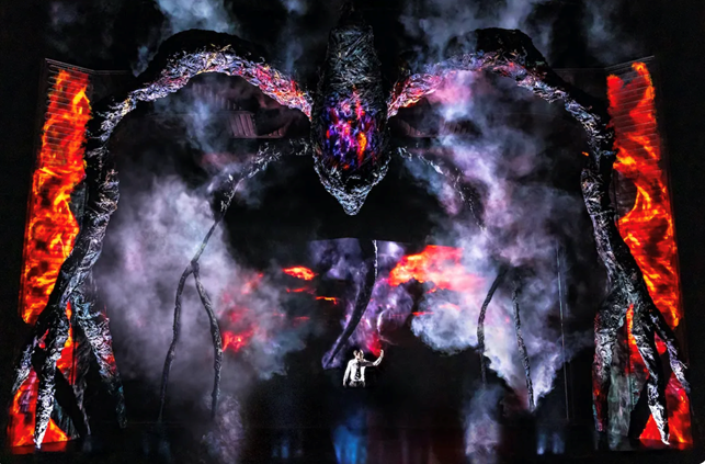 A large spider with smoke and flames
Description automatically generated