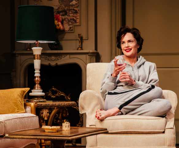 A person sitting in a chair holding a wine glass Description automatically generated