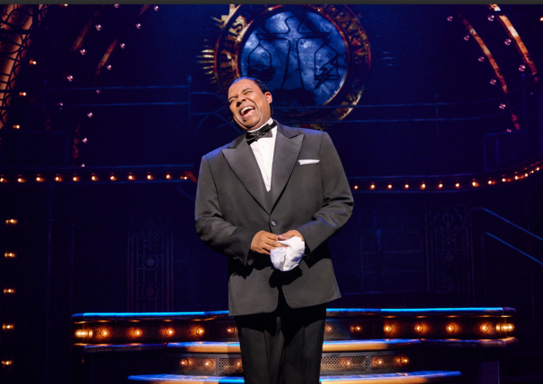 A person in a tuxedo laughing
Description automatically generated