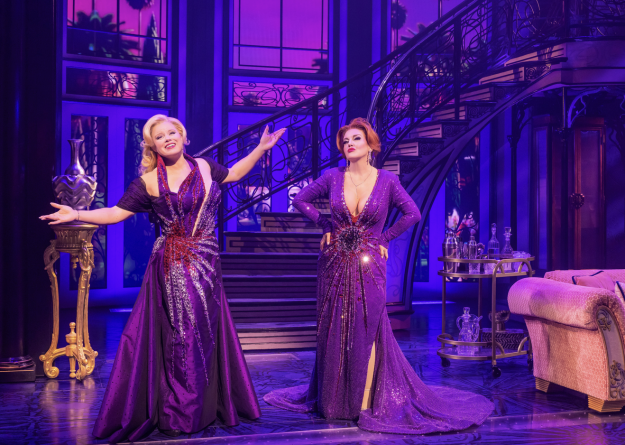 A group of women in purple dresses on a stage

Description automatically generated