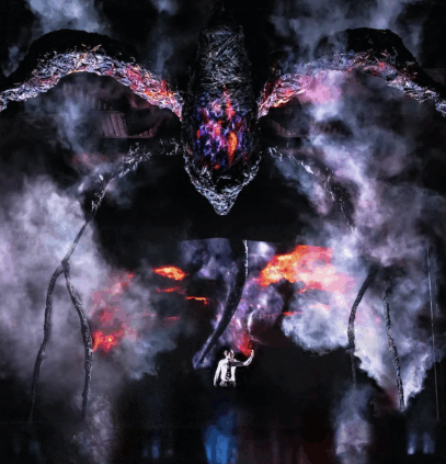 A large spider with smoke and flames

Description automatically generated