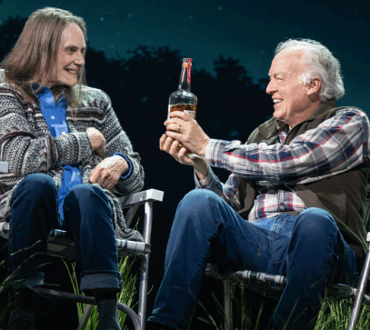 A person and person sitting in chairs holding a bottle of alcohol

Description automatically generated