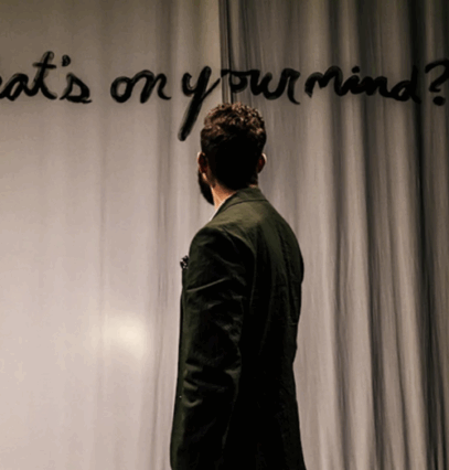 A person standing in front of a curtain

Description automatically generated