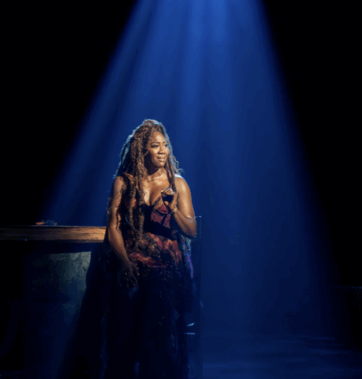 A person sitting on a chair with a light shining on her face

Description automatically generated