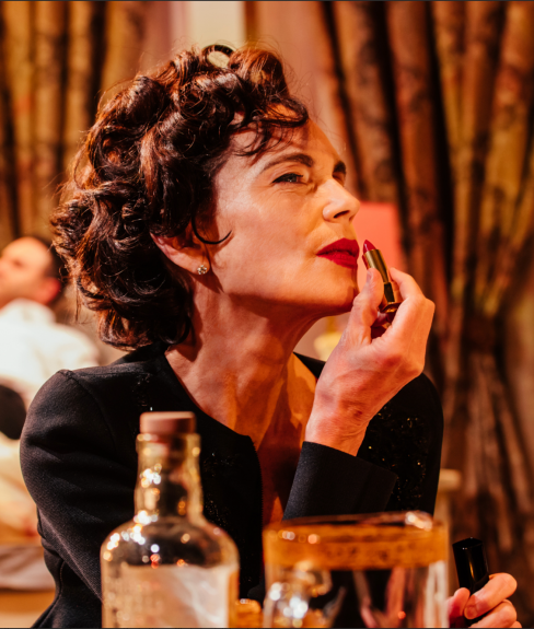 A person putting on lipstick
Description automatically generated