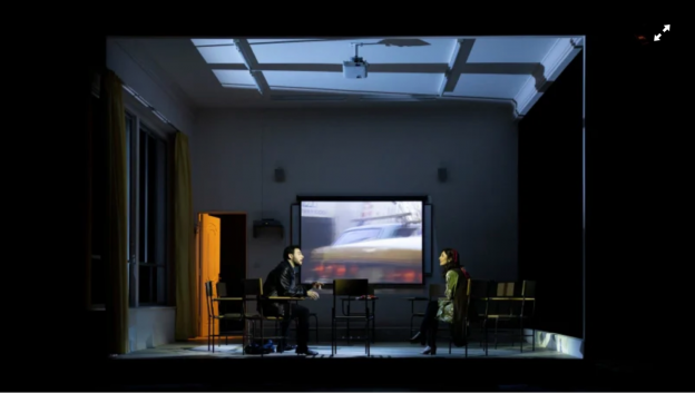 A person and person sitting in chairs in a dark room
Description automatically generated