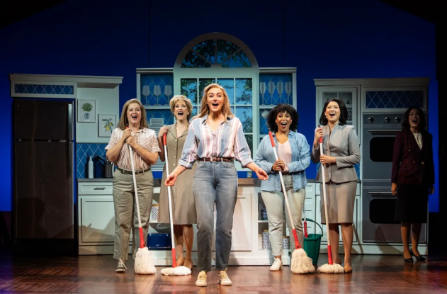 A group of women holding mops Description automatically generated