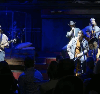 A group of men on stage with microphones and guitars

Description automatically generated