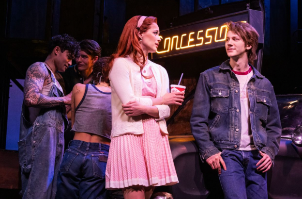 A group of people standing around a person Description automatically generated