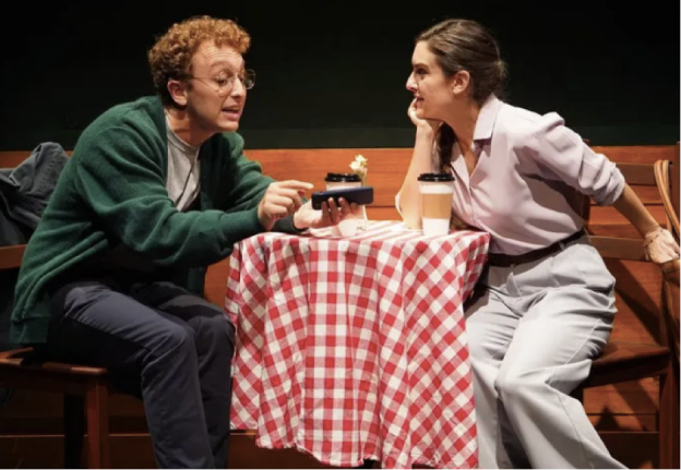 A person and person sitting at a table with a red and white checkered tablecloth Description automatically generated
