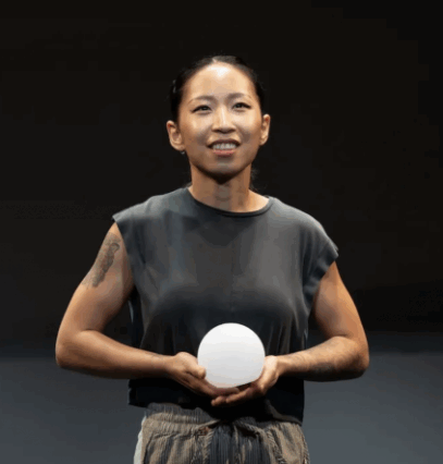 A person holding a white ball

Description automatically generated