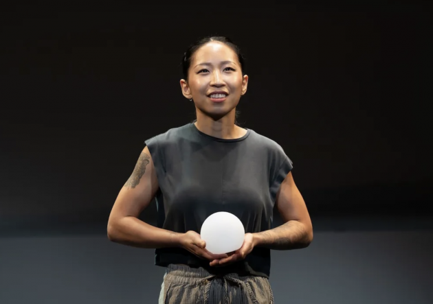 A person holding a white ball

Description automatically generated