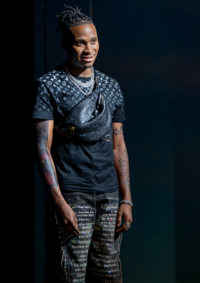 A person with tattoos on his arm

Description automatically generated