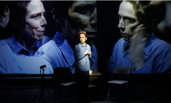 A person standing in front of a large screen

Description automatically generated