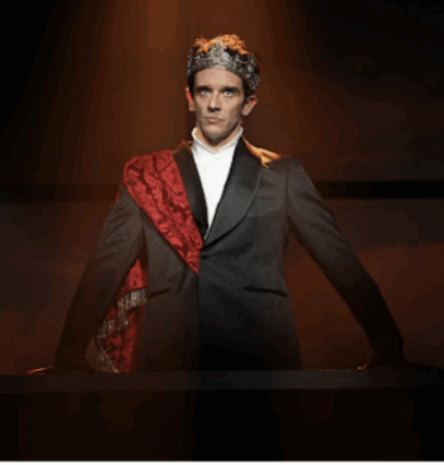 A person in a suit and crown

Description automatically generated
