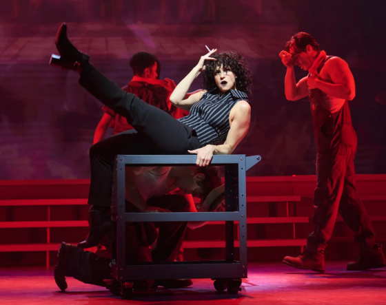 A person lying on a table with a person in the background Description automatically generated