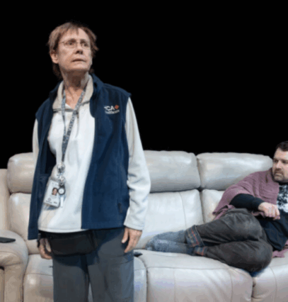 A person sitting on a couch next to a person lying on a couch

Description automatically generated