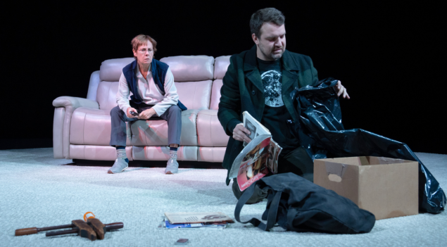 A person sitting on a couch with a dog and a bag

Description automatically generated