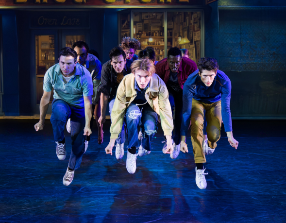 A group of men running on a stage Description automatically generated