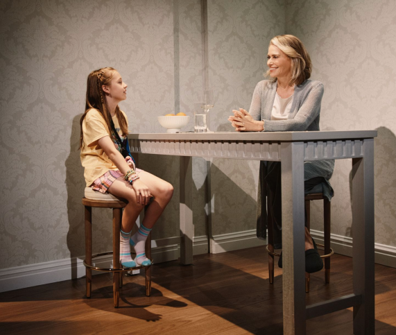 A person and a child sitting at a table Description automatically generated