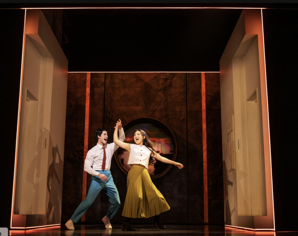 A person and person dancing on stage
Description automatically generated