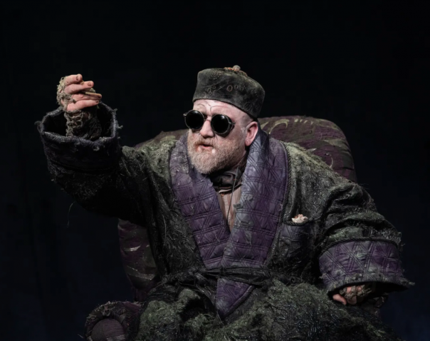 A person in a robe and hat Description automatically generated