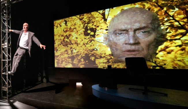 A person standing in front of a large screen Description automatically generated