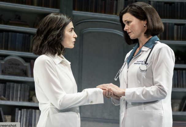 A person in white coat holding hands with another person in white coat Description automatically generated