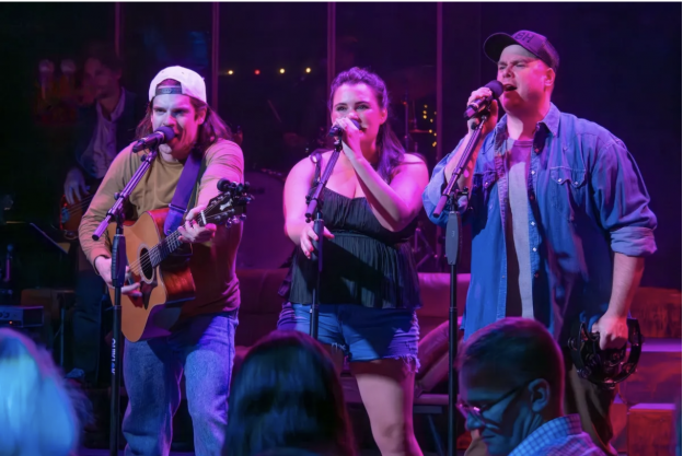A group of people singing and playing instruments
Description automatically generated