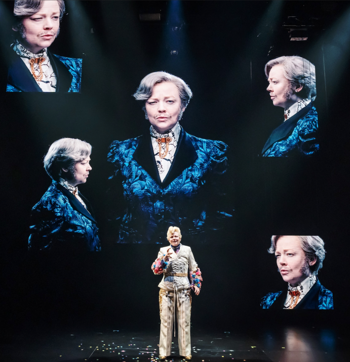 A person standing on a stage
Description automatically generated
