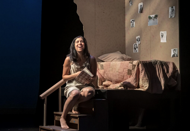 A person sitting on a step with a book and a bed