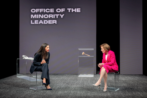 Two women sitting on chairs in front of a screen