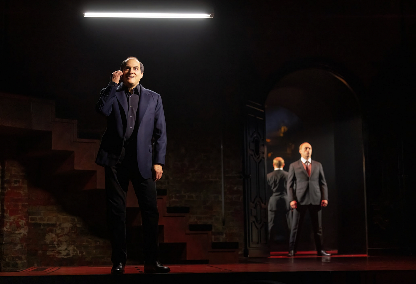 A person standing on a stage with a person in a suit