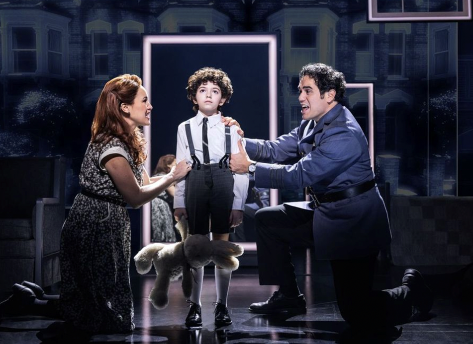 A person kneeling on a stage with a person holding a child's hand