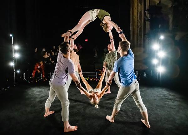 Photo Credit: Maike Schulz<br /><br />The audience looks on as company members balance Rachael Boyd (bottom) and Ashleigh Pearce (top).