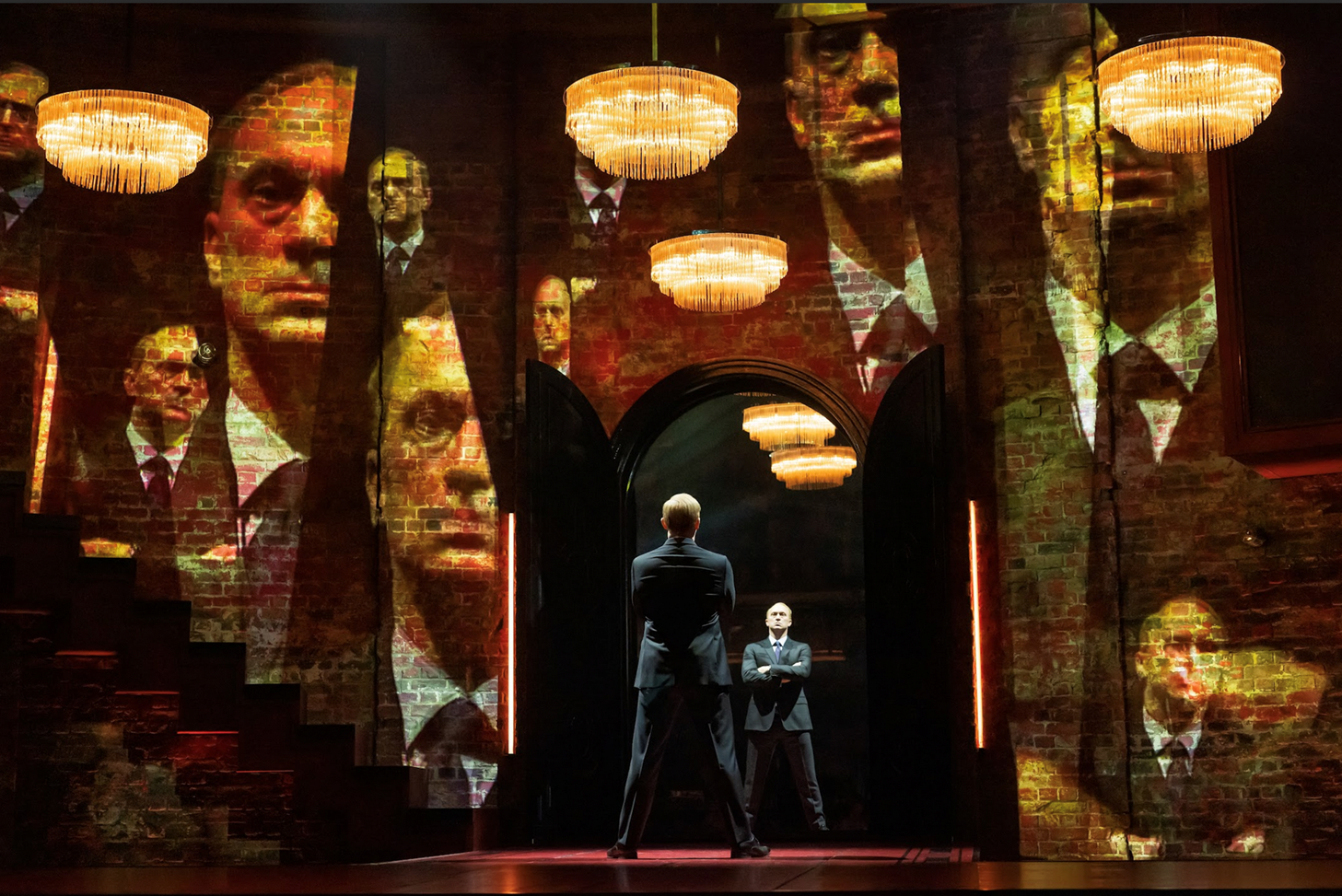 A person standing on a stage with a person in a suit