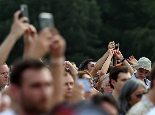 A crowd of people holding their hands up with medium confidence