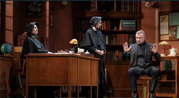A person in a black suit and black robe standing next to a person in a black suit